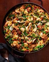 A pan of food with seafood and peas
Description automatically generated
